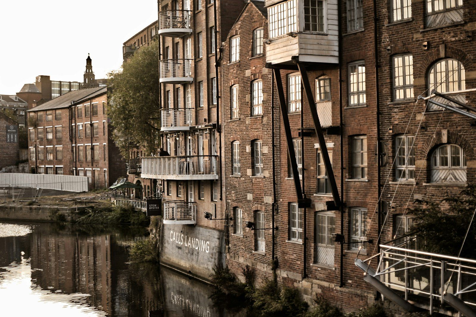 Brick mill building converted into apartments beside a canal