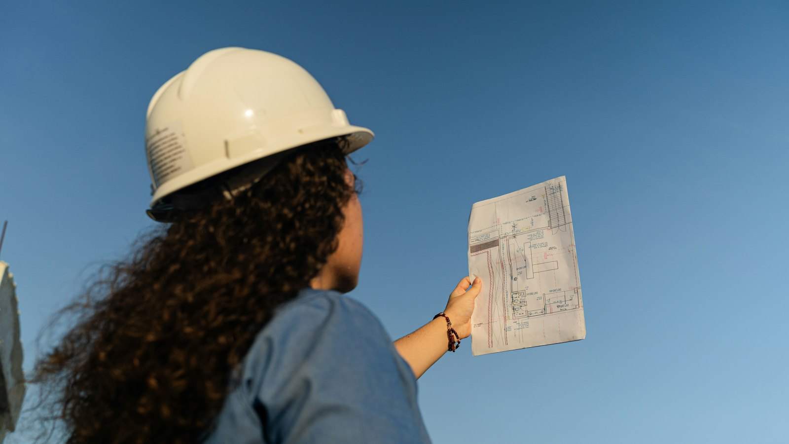 Surveyor reviewing a condition survey and plans on site